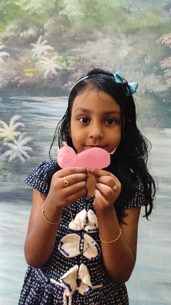 She is making a pig with paper for Cyboard School activity